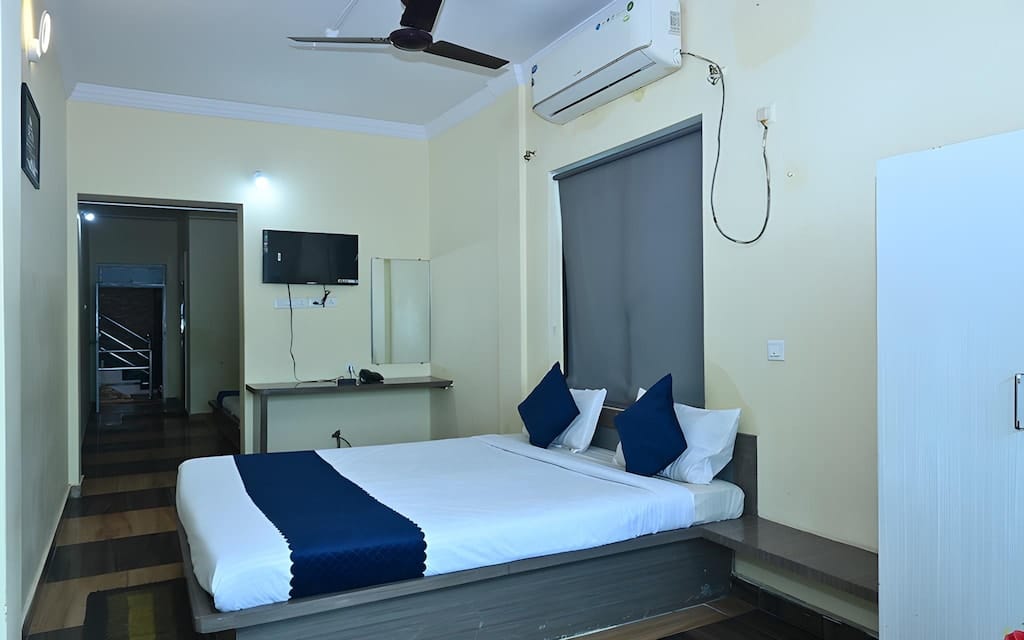 Deluxe air-conditioned room at Hotel Nataraj Puri with a king bed, television and study desk